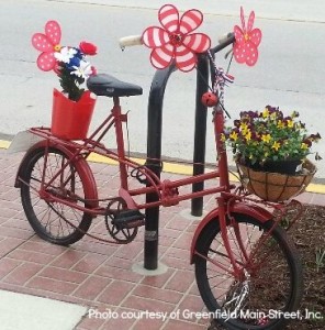 Whimsical red bike with basket of flowers